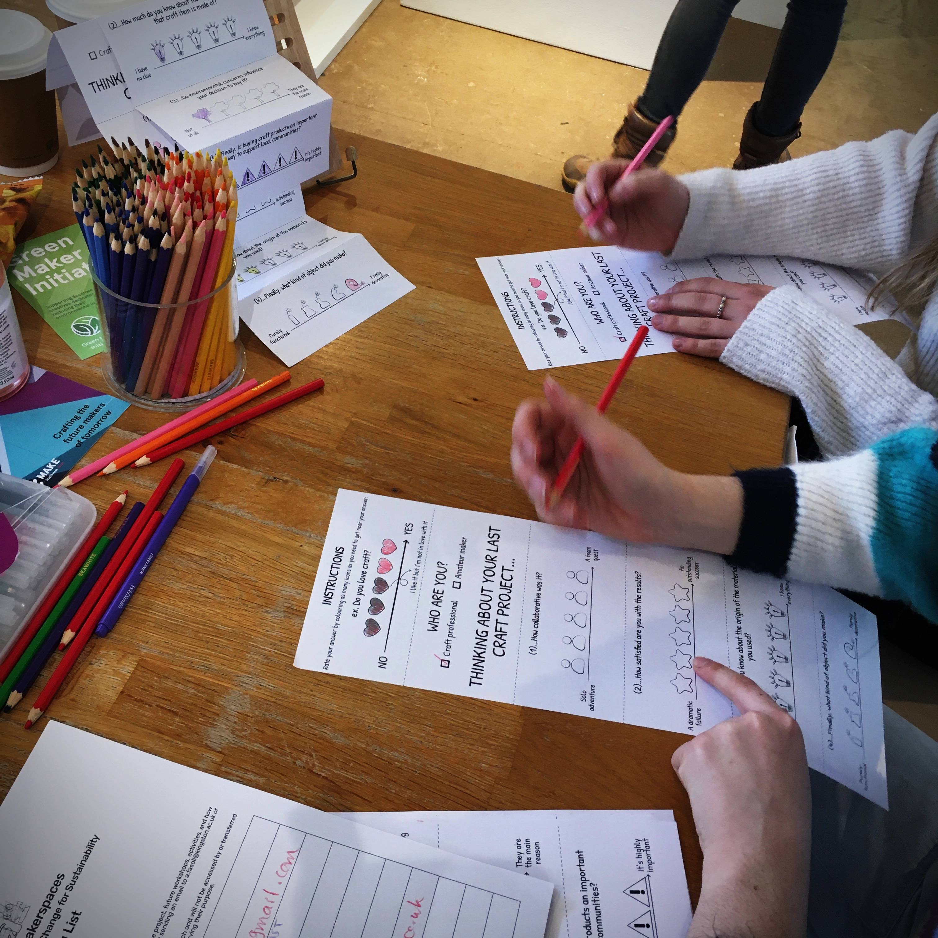 Picture of hands of two participants in the exploratory research colouring the icons of the survey to give their reponse.
